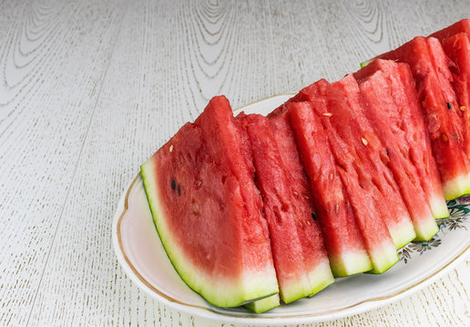 The sliced watermelon lies on an oval plate.