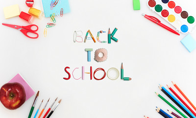 Colorful school supplies corner border over a white background with words Back to school. Pencils, paints, scissors, stickers. Education, school time, childhood concept. Copyspace, ready for ad.