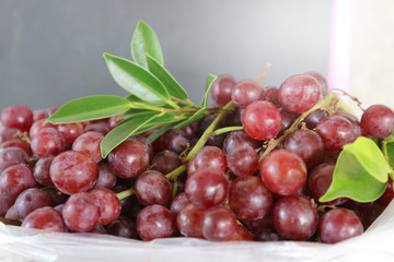 Ripe red grape with leaves in bag