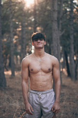 Foto en medio de un bosque con un joven musculoso 