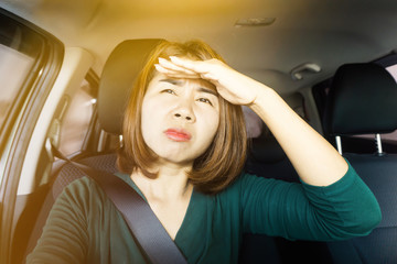 Asian woman driving car with problem short sight eye vision and blur with sunny light 