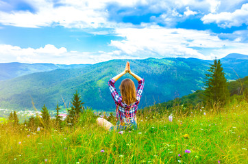 Yoga in the mountains. Beautiful girl is meditating in asana. amazing summer nature around. Harmony and wanderlust concept. Hipster travelling. Stylish woman enjoying life.
