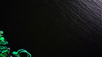 Office / Büro Collage / Hintergrund Bürosortiment auf schwarzem Hintergrund mit Gummiband, Reißzwecken, Büroklammern, Binder-Clips und Freiraum für ihren Text (Copy Text) licht von oben rechts