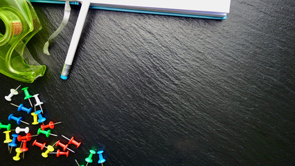 Office / Büro Collage / Hintergrund Bürosortiment auf schwarzem Hintergrund mit Pins, Tesaabroller, Notizbuch, Stift und Freiraum für ihren Text (Copy Text)