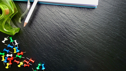 Office / Büro Collage / Hintergrund Bürosortiment auf schwarzem Hintergrund mit Pins, Tesaabroller, Notizbuch, Stift und Freiraum für ihren Text (Copy Text)