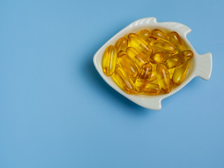 Fish oil capsules with omega 3 and vitamin D in a fish bowl, sport, healthy lifestyle, medicine, nutritional supplements and people concept,close up shot.