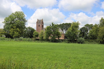 Fototapeta na wymiar Dutch meadow and church in the background.