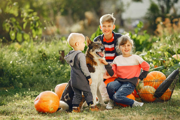 Family in a garden. Children with pumpkins. Kids playing with dog