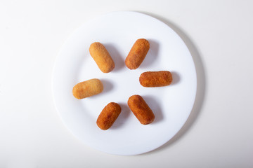 Tasty and delicious Deep-fried Croquettes orderly displayed on a white plate.