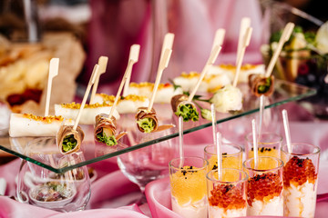 Beautiful appetizer on a wedding table on a pink tablecloth