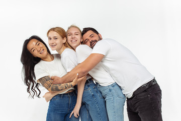 Group of adorable multiethnic friends having fun isolated over white studio background. Copyspace. Diversity, inclusion, friendship and love concept. Different nationalities united with sincere