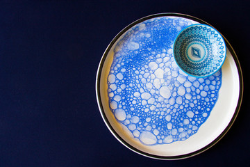 Blue tableware, bowl and plate on the blue table. Dish set. Table setting.