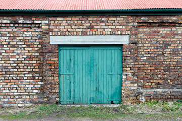 Green painted sliding door on an old abandoned industrial building. Big Pit was a working coal mine...