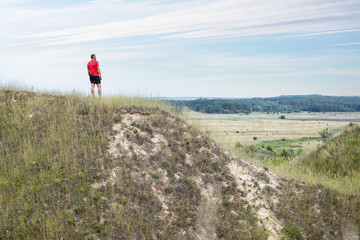 Bearded runner sportsman standing on the hill