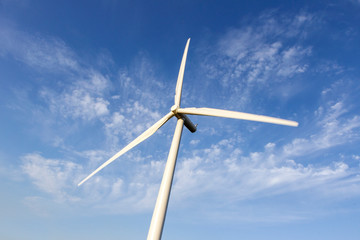 Single wind turbine with blue sky background from directly below.