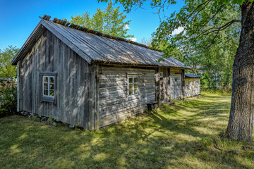 An old weathered timber residential house with greyed wooden roof from one of Turku archipelago island at summer day. Finland.
