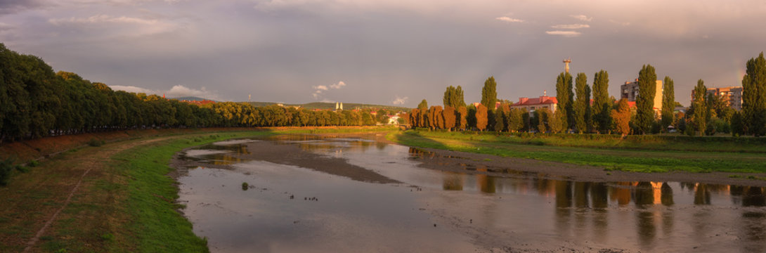 Amazing panoramic view of Uzhhorod at sunset, scenic summer landscape with the river Uzh, embankment and the longest linden alley in Europe, Zakarpattia, Ukraine, Eastern Europe