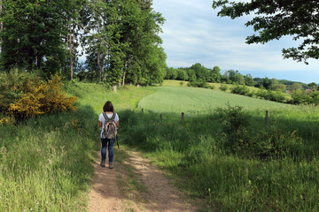 Woman walking on a rural dirt road in Central France