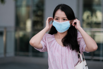 Asian women wear surgical masks to prevent the COVID-19 virus