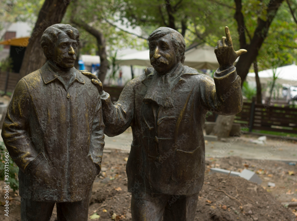 Wall mural Statues of two walking men photo side