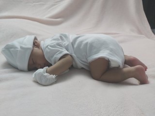 A baby lying on the mattress.