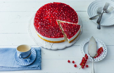 Cheesecake. Coffee table with currant cake on cake plate. A piece is cut out