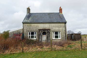 Small double fronted, abandoned farmhouse cottage in a remote location in Wales. Double fronted detached property in need of renovation.