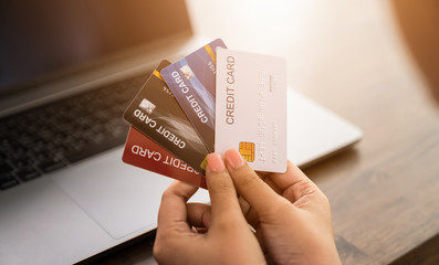 Woman holding a credit card and uses computer laptop to pay online. The concept of online shopping...
