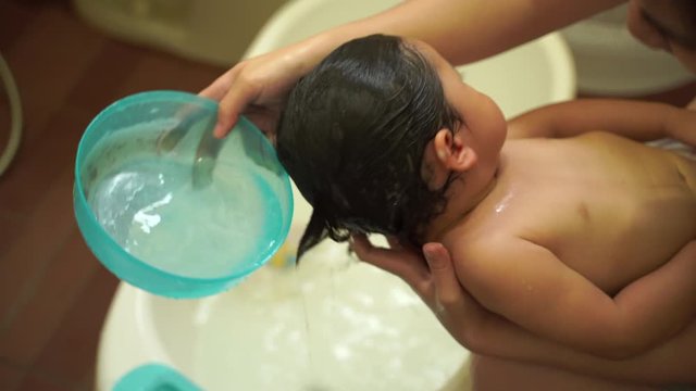 cute baby taking shower with her mother