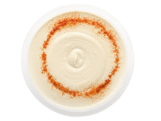 Fresh hummus with paprika in a transparent plastic bowl isolated on a white background. Design element for product label, catalog print, web use. Top view. Flatlay.