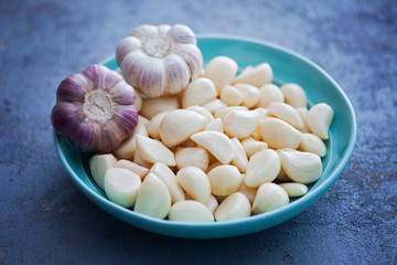 bowl with garlic cloves and head on board
