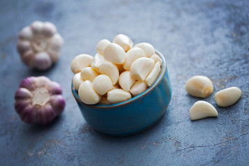 bowl with garlic cloves and head on board
