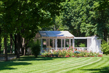 Summer gazebo with flowers in the city park.