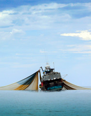 Large fishing trawlers are fishing in the sea.