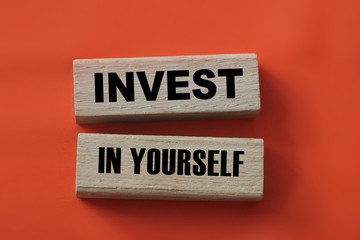 Invest In Yourself words on wooden blocks on red. Education and self motivation concept