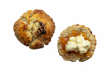 An individual walnut scone with cream and jam