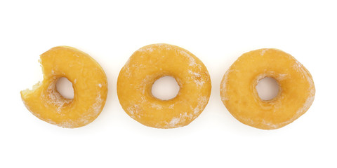 Three fresh donuts with powered sugar isolated on white background. Donut with bitten on left side.