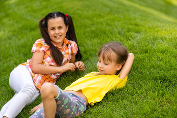 Portrait of two little girls sisters fighting on home backyard. Friends girls having fun. Lifestyle candid family moment of siblings quarreling playing together.
