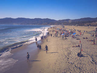 People visit the beach in Santa Monica, California. People are swimming, sunbathing, surfing and enjoying the great weather in santa monica beach.