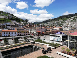 Fototapeta na wymiar Historic Center of Quito with views of mountains and houses. Image taken overlooking the avenue 24 de mayo and its boulevard. In the background mountains during a sunny day