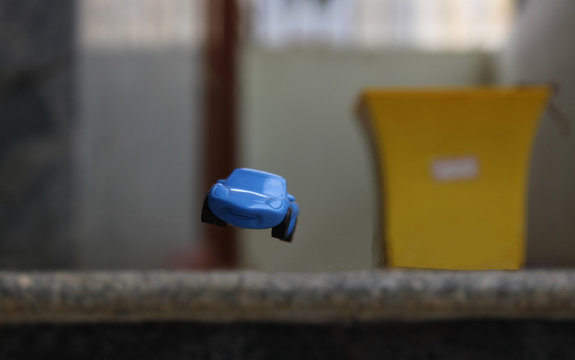 Selective focus on a toy car falling off a plight of stairs.