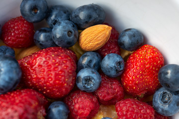 Healthy eating, food concept. Bowl of corn flakes and fresh berries and fresh fruits on the green grass.