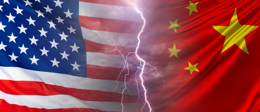 The confrontation between the US and China. Flags of the PRC and the United States and lightning between them. Problems in relations between America and China.