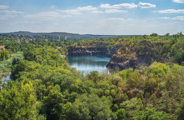 Fototapeta na wymiar A flooded granite quarry on a steppe landscape. Karachunovsky granite quarry on the outskirts of the city of Kryvyi Rih near the reservoir of the Ingulets river.