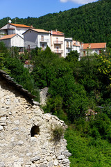 Rudere inquadrato in primo piano, con sfondo piccolo paesino italiano, borgo