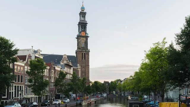 A wide day-to-night (Holy Grail) timelapse of a cityscape on the Prinsengracht with Anne Frank's house and the Westerkerk church in Amsterdam, in summertime with some clouds.