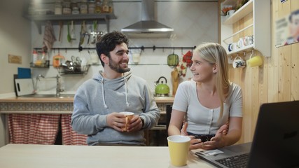 Happy couple having breakfast. Young man brings coffee to his girlfriend or wife