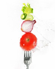 on a white table on white plates are two hamburgers with different fillings, next to cucumbers and tomatoes