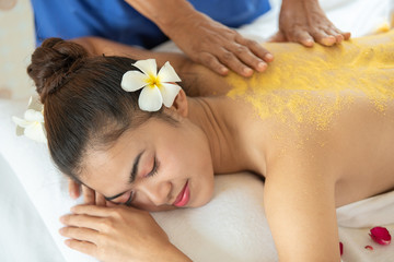 Obraz na płótnie Canvas Beautiful Asian woman having exfoliation treatment with body scrub in spa salon, scrubbing and skin care concept, enjoying and relaxing time