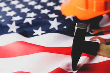 Safety helmet and hammer on american flag background, space for text